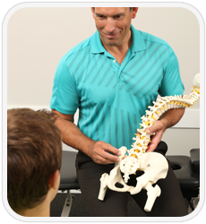 chiropractor talking to young boy about his back